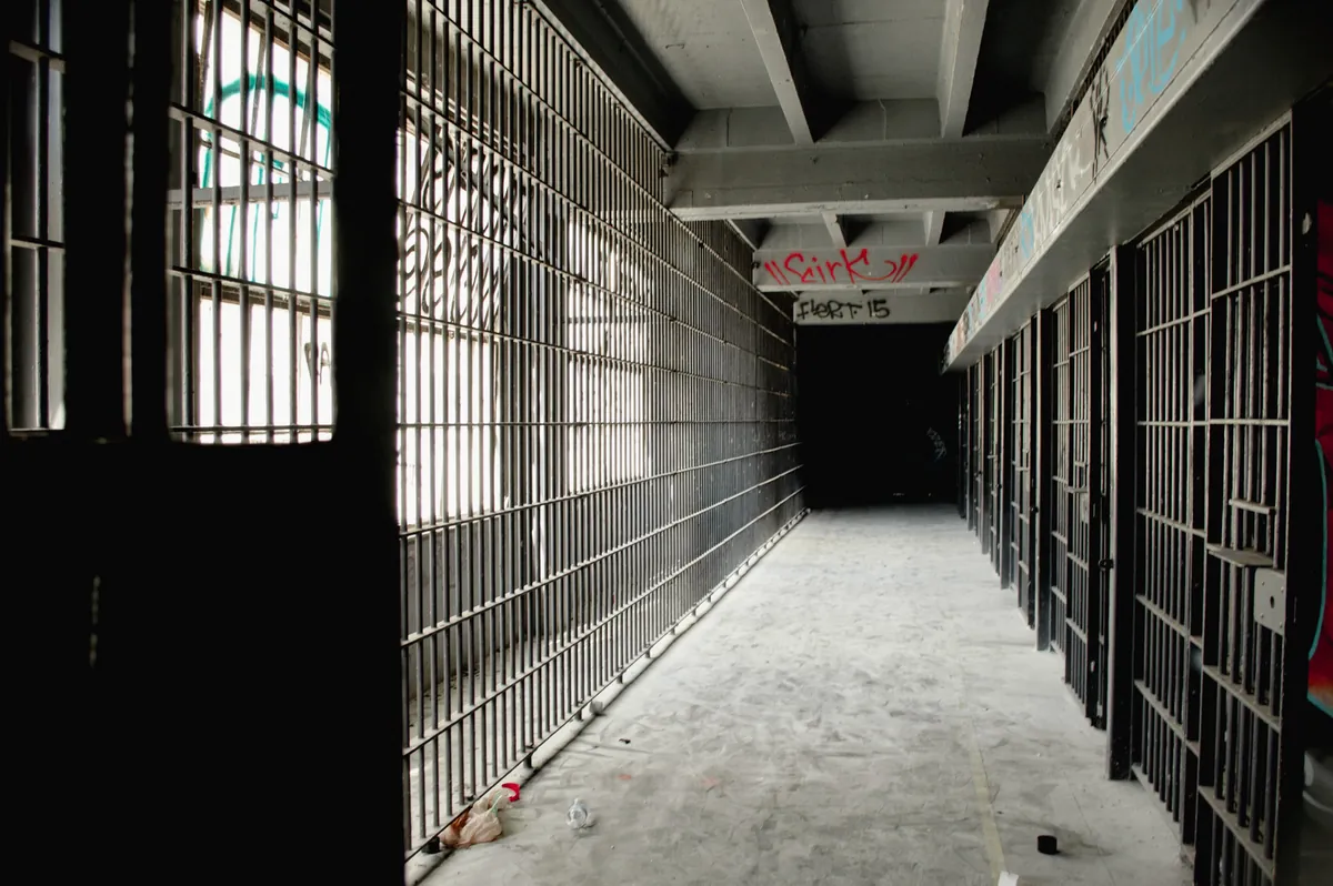 Empty corridor of barred cells in an abandoned jail