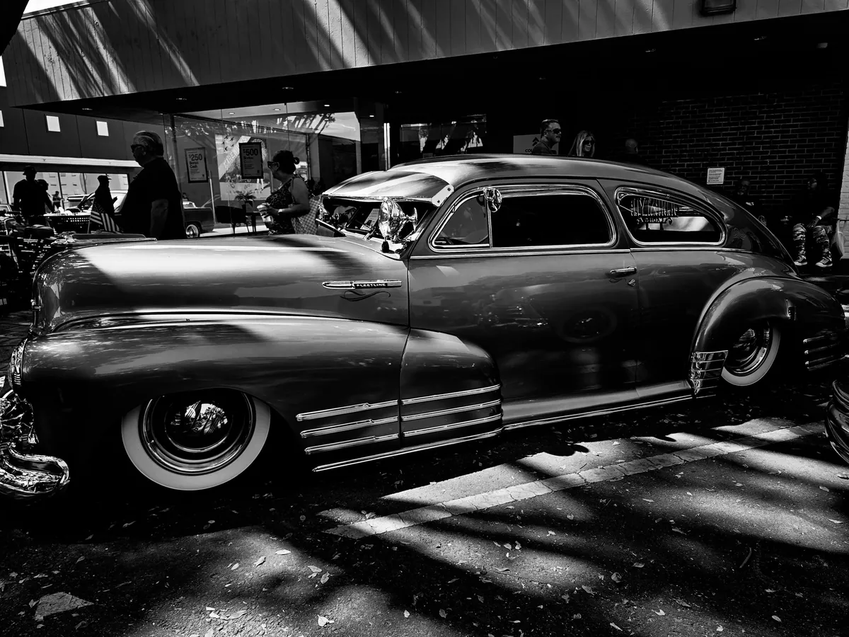 Black and white photo of a 1940s classic car at a car show