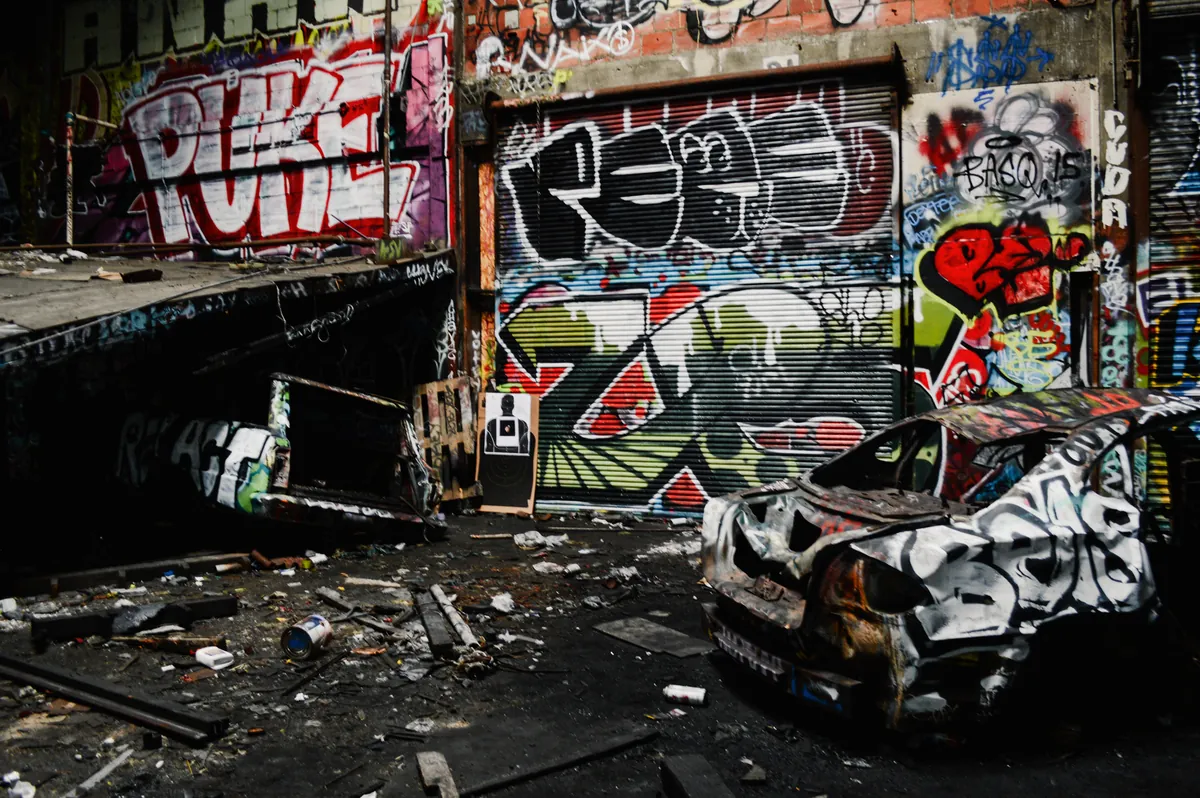 Wrecked car inside a graffiti-covered abandoned building