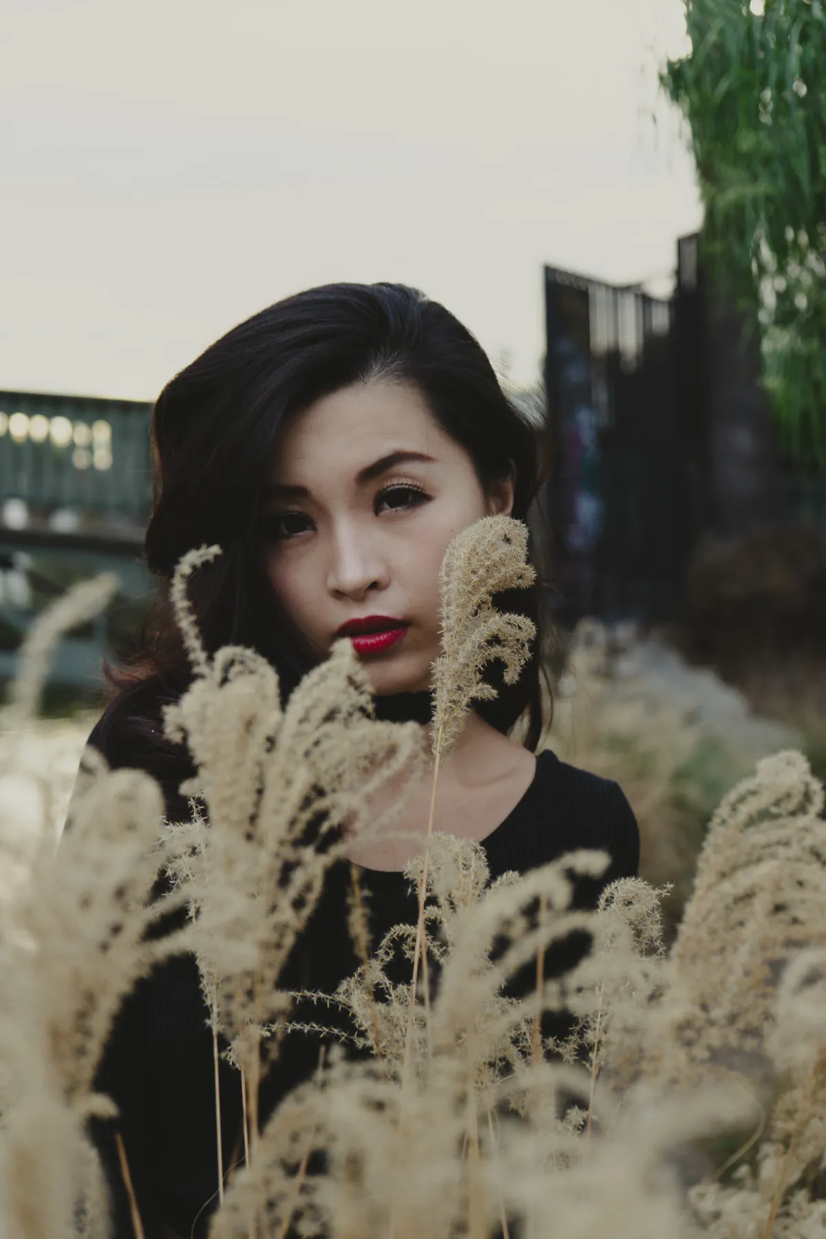 Woman with red lipstick framed by pampas grass