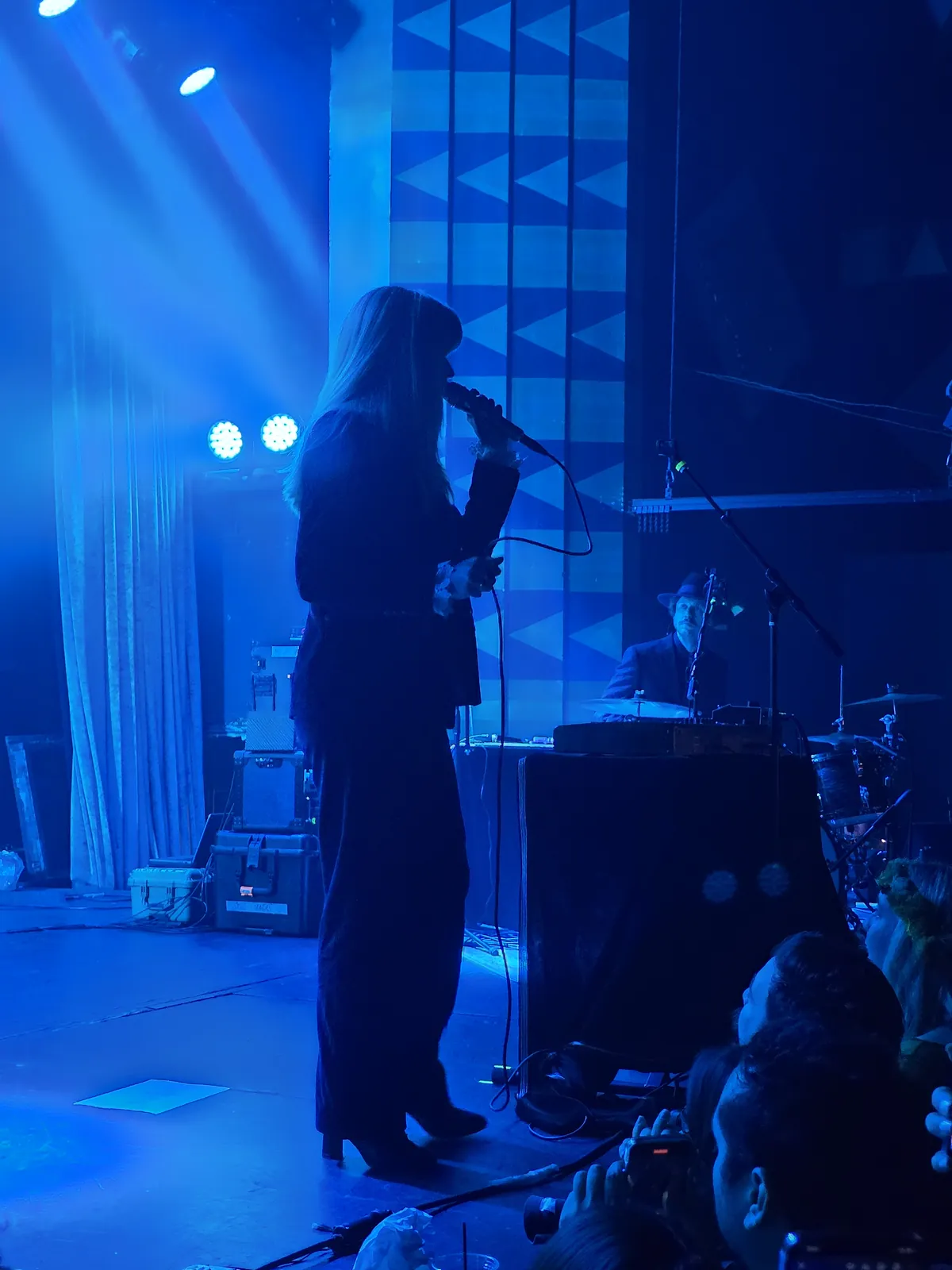 Singer silhouetted on a stage washed in blue light