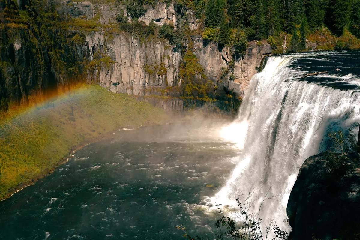 Waterfall with a rainbow arcing through the mist